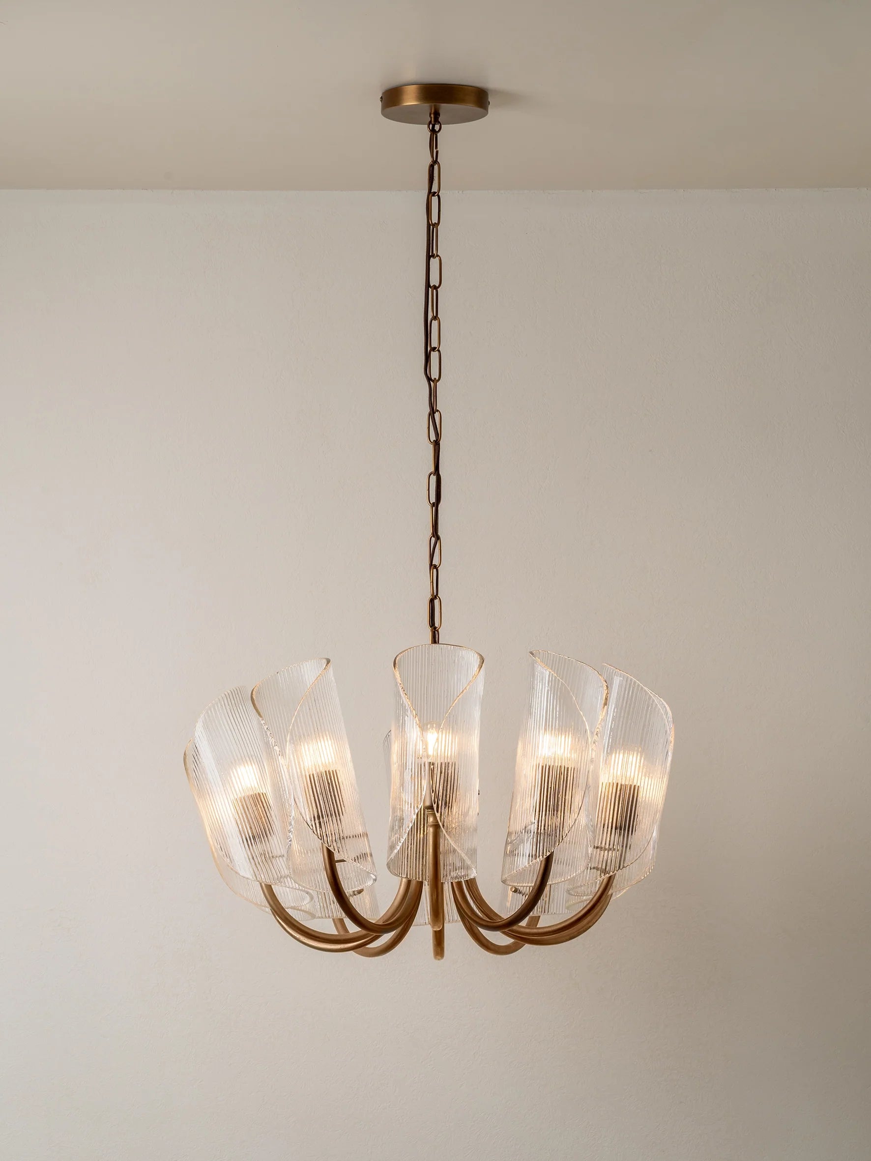 Cannoli - 10 light aged brass and textured glass chandelier