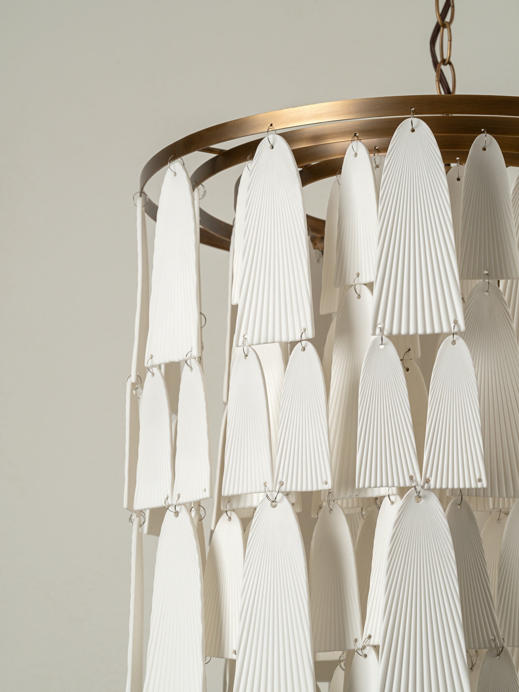 Kaolin - 4 light tiered aged brass and porcelain chandelier